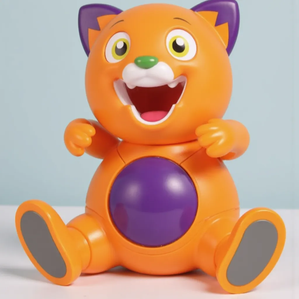 Lucas Goes Pop toy from Goilath games, Decpicting Cartoon orange cat character with a purple spot on his belly, purple spots on the edge of his orange ears, green nose, and yellow eyes, Open Mouth, and smile
