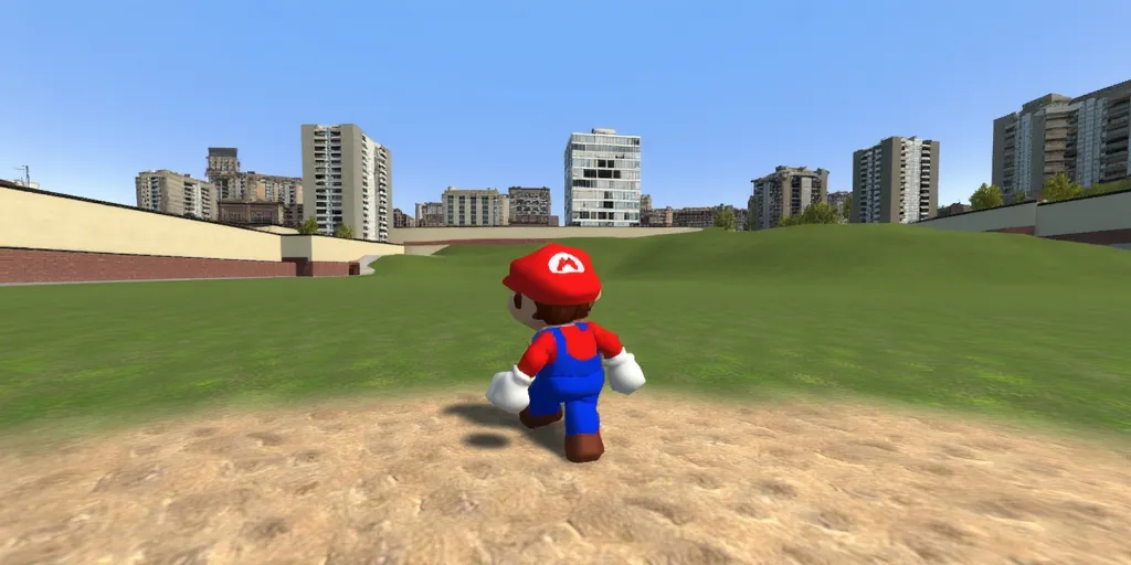 SM64Mario in gm_construct, a scene from the video game "Garry's Mod" featuring a virtual urban landscape. The image shows an open area with a mix of grass and sand in the foreground, bordered by modern buildings in the background. The sky is clear and blue, and the environment appears to be part of a digital sandbox setting.