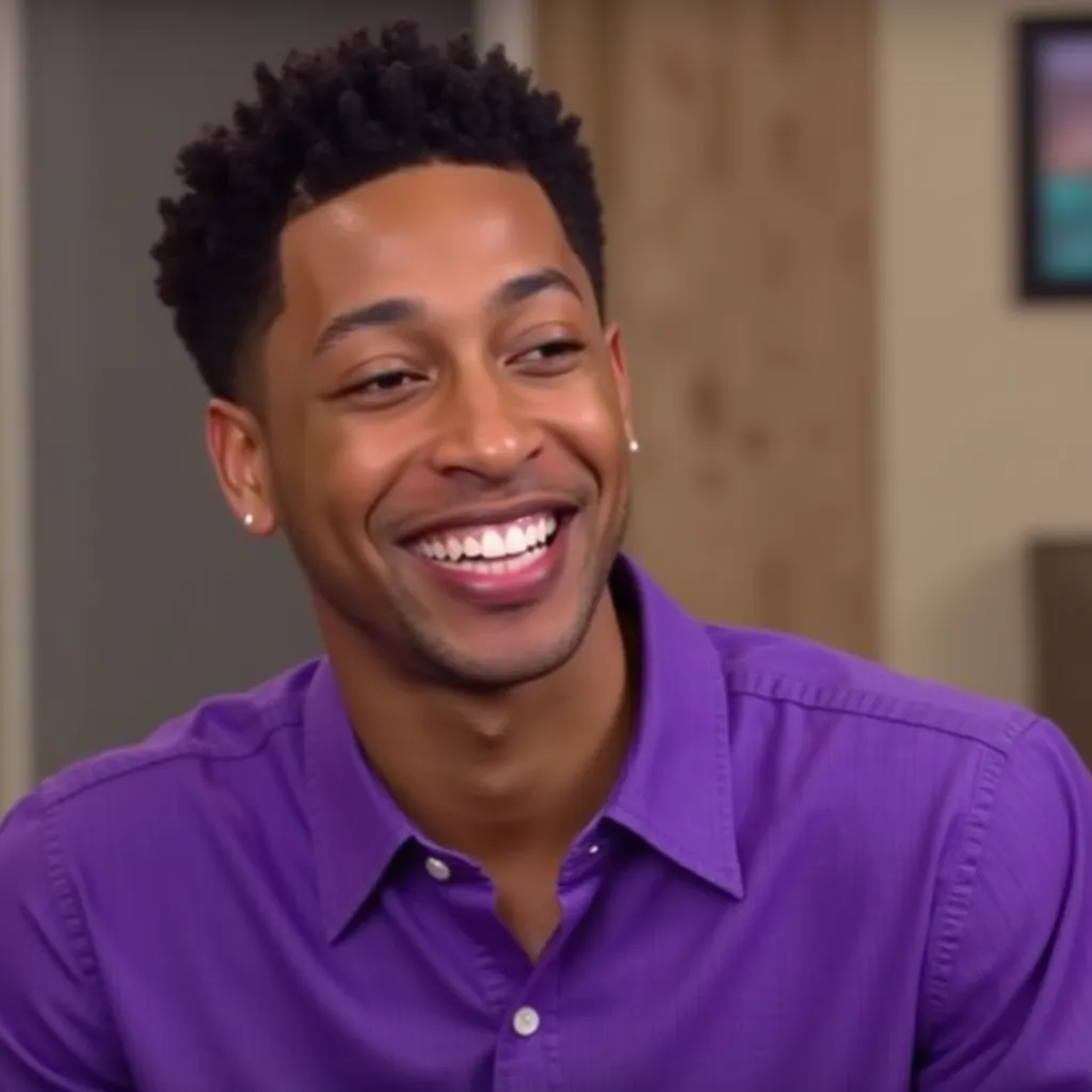 Jacob Latimore with purple shirt smiling showing teeth in video call Interview